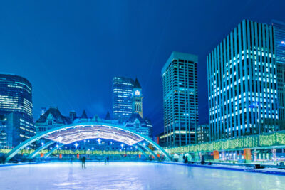 Nathan Phillips Square skating rink in downtown Toronto, Ontario, Canada on a winter evening, night.