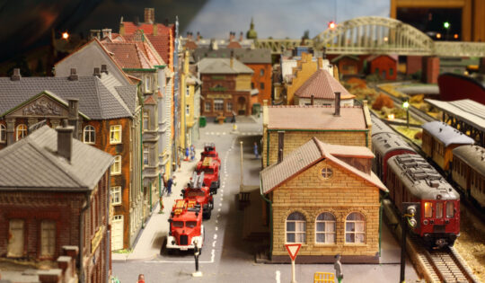 Model railroad layout with trains, fire brigade vehicles and houses.