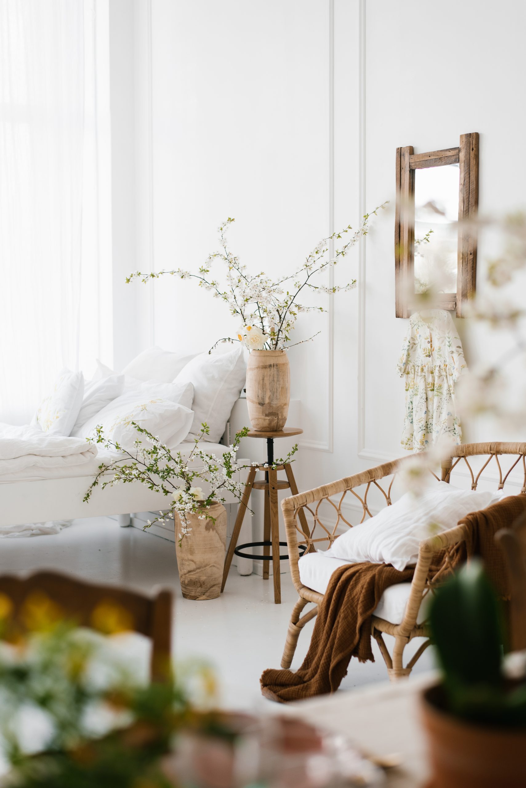 The interior of a beautiful white modern bedroom with spring flowers